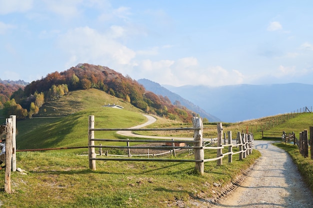 Picturesque alps autumn landscape wooden fence and mountain hills in lombardy italy