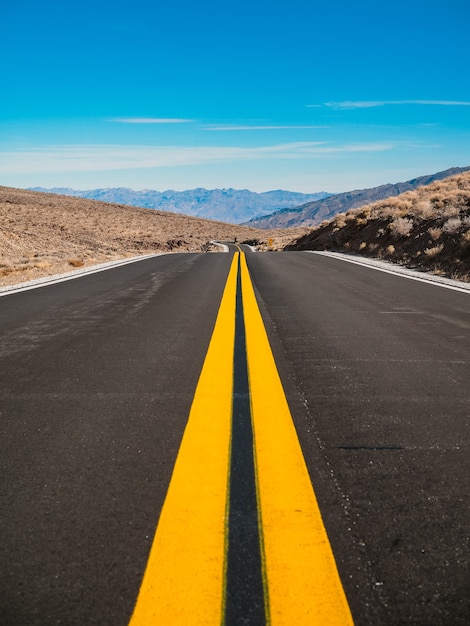 The picturesque empty road in Death Valley with a view of the hills