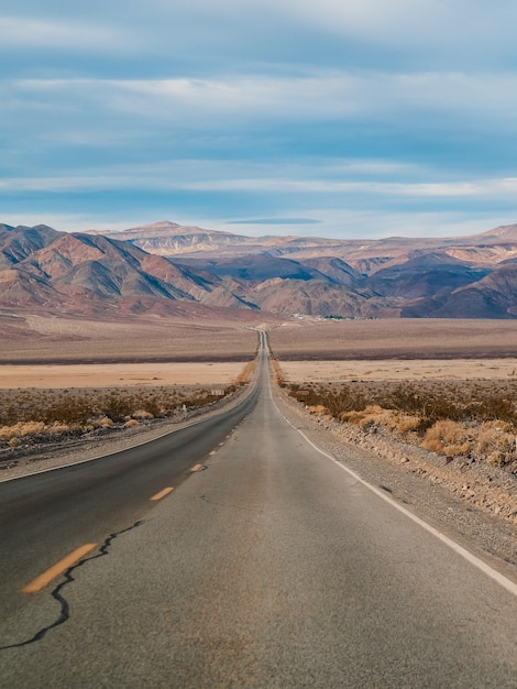 The picturesque empty road in Death Valley with a view of the hills