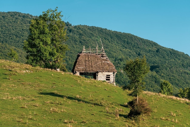 Picturesque landscape with old traditional wooden barn on hill, Apuseni, Romania.