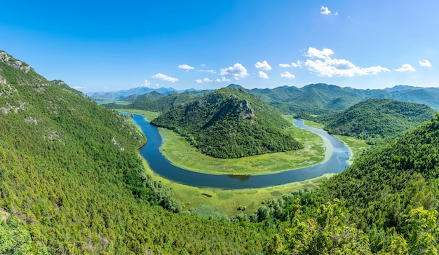 The picturesque meandering river flows among green mountains