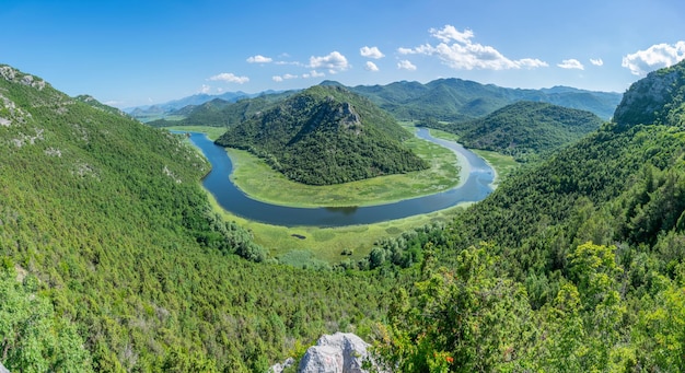 The picturesque meandering river flows among green mountains