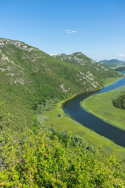 The picturesque meandering river flows among green mountains