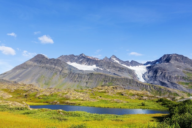 Picturesque Mountains of Alaska in summer. Snow covered massifs, glaciers and rocky peaks.