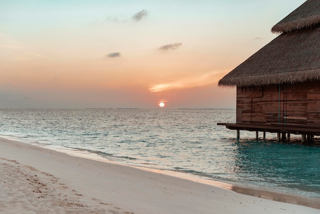 Picturesque sunrise in the Maldives island the sun rising from the Indian ocean and reflected in the water travel concept