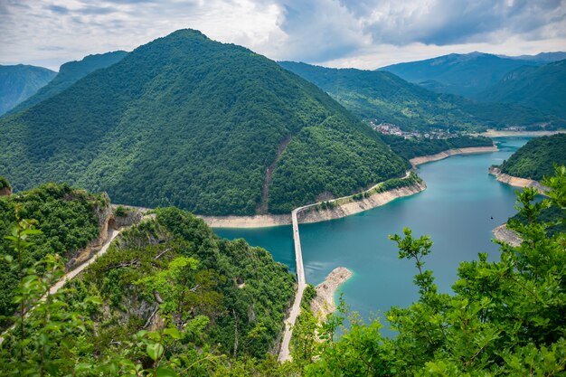 A picturesque turquoise lake can be seen from the top of a high mountain.