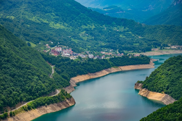 A picturesque turquoise lake can be seen from the top of a high mountain.