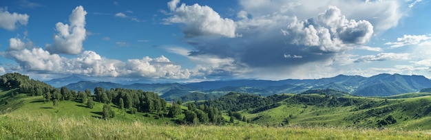 Picturesque valley panoramic mountain view Bright sunlight spring greens of forests and meadows