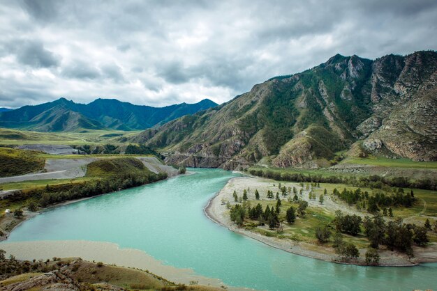 Picturesque view on the confluence of two mountain rivers. Katun river and Chuya river against of Altai mountains, Russia