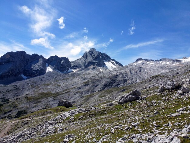 Picturesque view of snowy mountain slopes with rocky peaks and blue sky Tourist scenic landscape