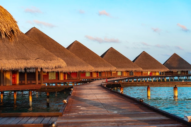 Picturesque view of the water villas at sunrise in the Maldives the concept of luxury travel