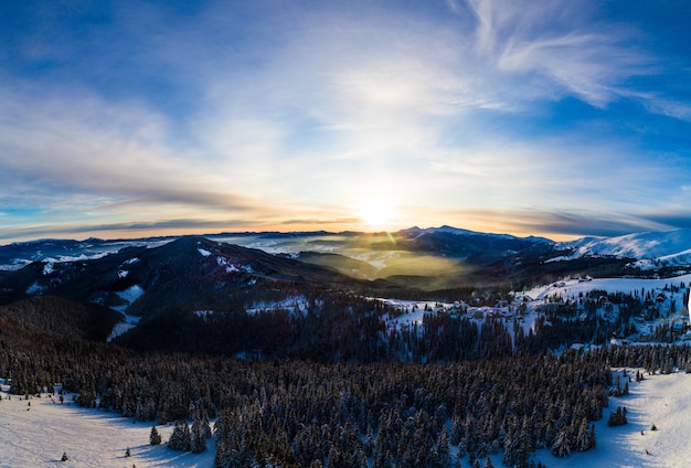 Picturesque winter panorama of mountain hills covered with snow