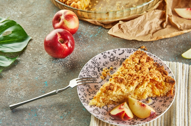 Pie in a baking dish and a slice on a plate with peaches and pears