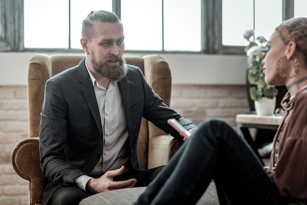 Piece of advice. Bearded experienced psychologist giving piece of advice to emotional teenage girl