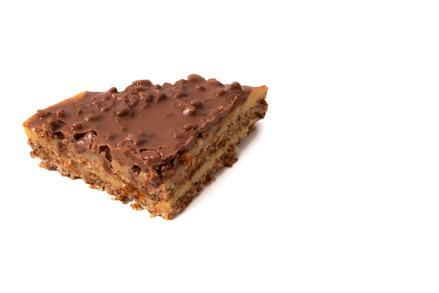 Photo a piece of almond cake with chocolate and crunchy caramel isolated on a white background