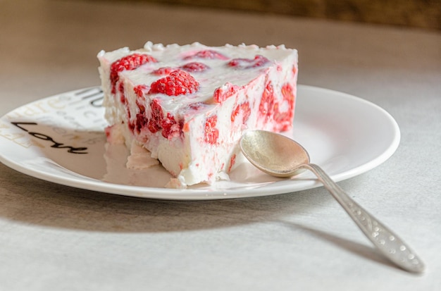 A piece of appetizing raspberry pie on a white plate with love.