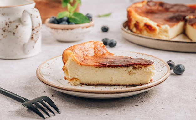 Photo a piece of basque burnt cheesecake put the whole cake is at the background tarta de queso selective focus