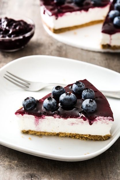 Piece of blueberry cheesecake on wood table