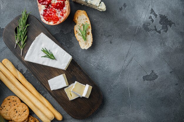 Piece of the brie cheese set, on gray table, top view 