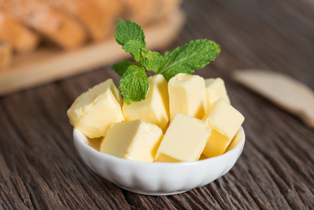 Piece of butter in white bowl.