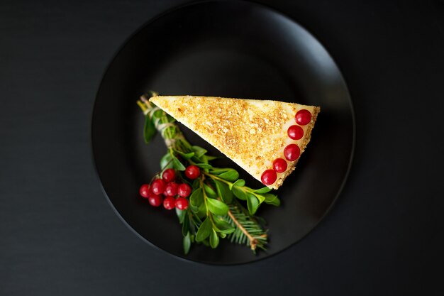 Piece of cake decorated with branches and berries