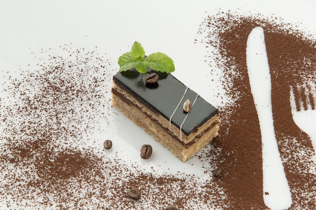 A piece of cake with sprinkled with powdered sugar on a white background