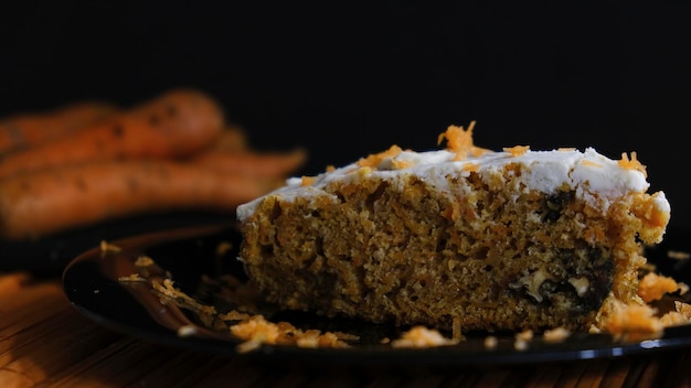 Piece of carrot and cinnamon cake on dark background. darkfood