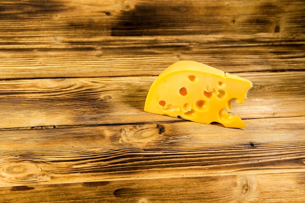 Piece of cheese on the wooden background