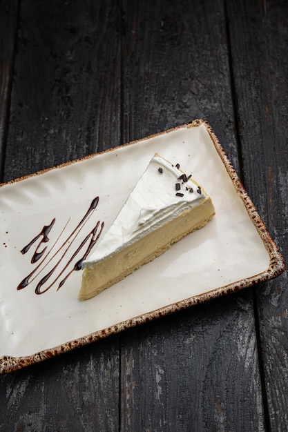 piece of cheesecake with cream and chocolate on a white plate