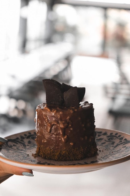 Photo a piece of chocolate cake with chocolate frosting on a plate