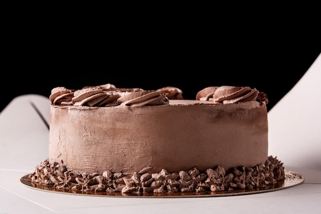 Piece of chocolate truffle cake inside the box and black background