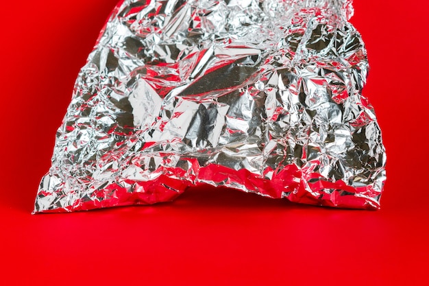 A piece of crumpled foil on color surface