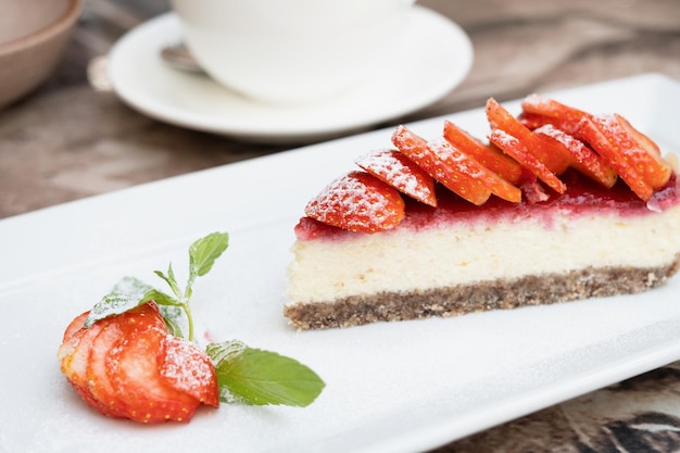 Piece of delicious cheesecake with berries on table close up