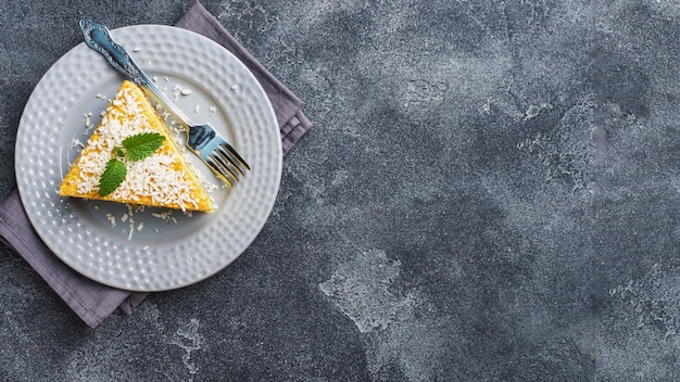 Piece of delicious puff cake with butter cream and berry jam on a plate with mint.