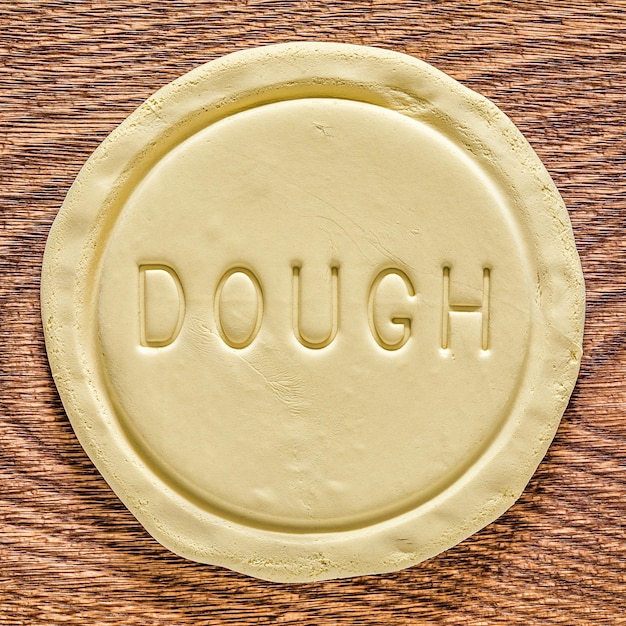 A piece of dough on an oak wood cutting board