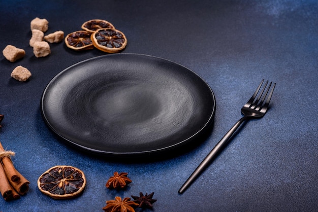 A piece of fresh delicious cake with nuts and chocolate on a black plate against a dark blue background