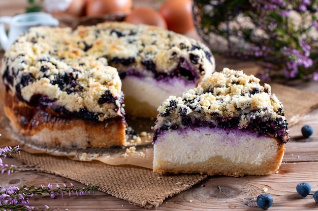 Piece of homemade blueberry cake with berries on wooden table close up