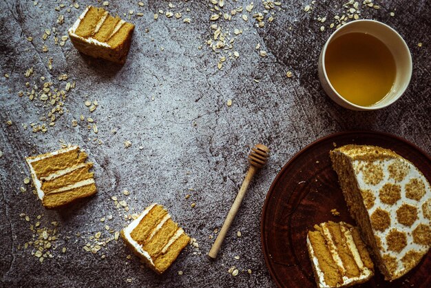 Piece of honey cake honey on a large earthenware plate oatmeal on a gray background 1