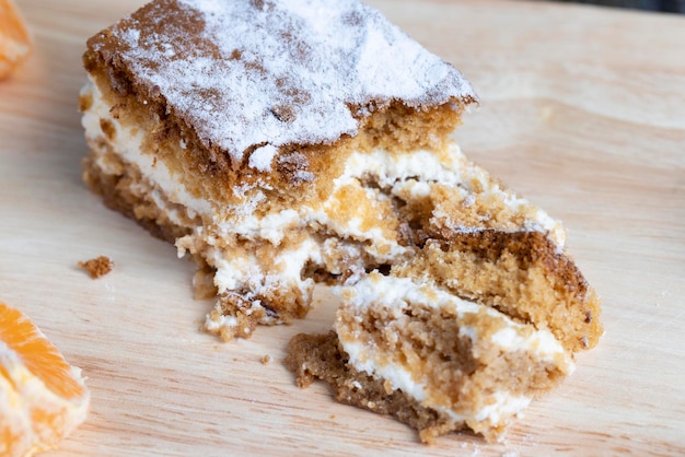 A piece of honey cake with vanilla cream and citrus tangerines