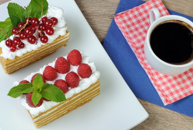 Piece of honey cake with whipped cream and raspberries