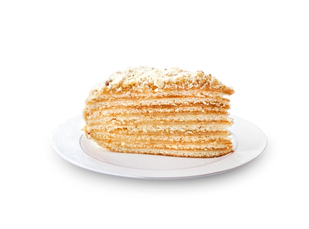 Piece of layer cake with custard and walnuts on a plate isolated with clipping path