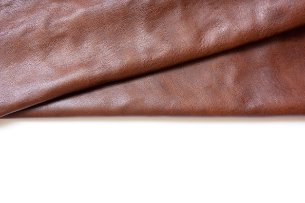 Piece of natural brown leather Materials for leather craft Copy space  Top view Handmade craft Isolated in white