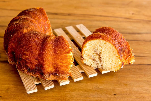 Piece of orange cake on wooden table.