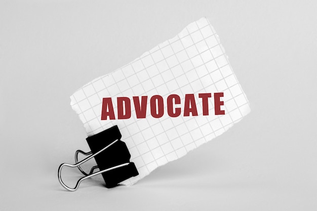 Piece of paper on a grey background with text advocate