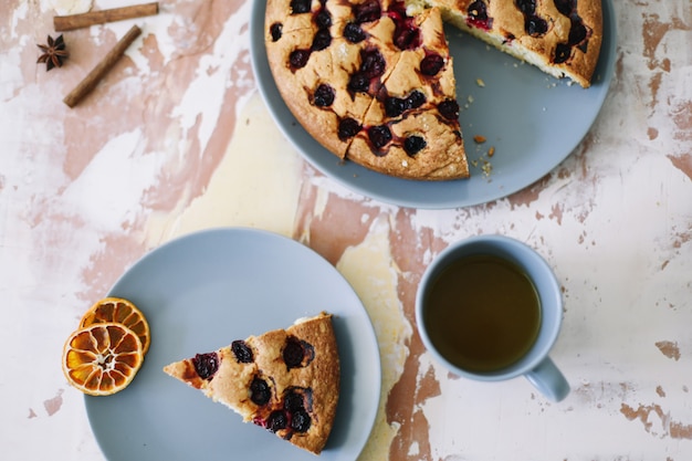 piece of pie on plate with cup of tea on white table breakfast