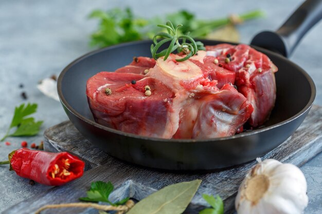 Piece of raw beef shank for Osso Buco and a sprig of rosemary