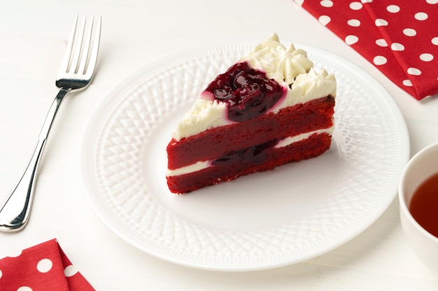 Piece of red velvet cake on white table