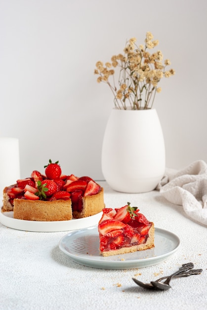 A piece of summer pie with fresh strawberry on a plate, ready to eat