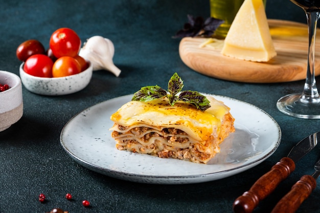 Piece of tasty hot lasagna on light background. Traditional italian lasagna. Italian food. Close up lasagna. Bolognese sauce. Bechamel sauce. Still life of food. Homemade meat lasagna.