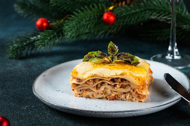 Piece of tasty hot lasagna on light background Traditional italian lasagna Italian food Close up lasagna Lasagna with christmas decor Still life of food Homemade pasta